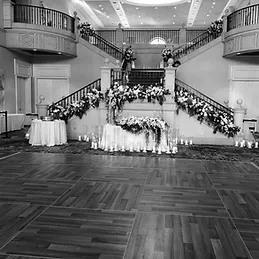 The ballroom at the Club at Ruby Hill, a double staircase dressed in flowers above an empty dance floor