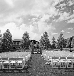 Rows of white chairs on the lawn at Rosewood Sand Hill, set for a ceremony under a big sky