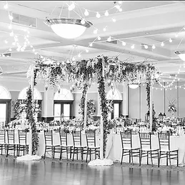 The ballroom at Villa Ragusa, a canopy of greenery over the head table and string lights across the ceiling